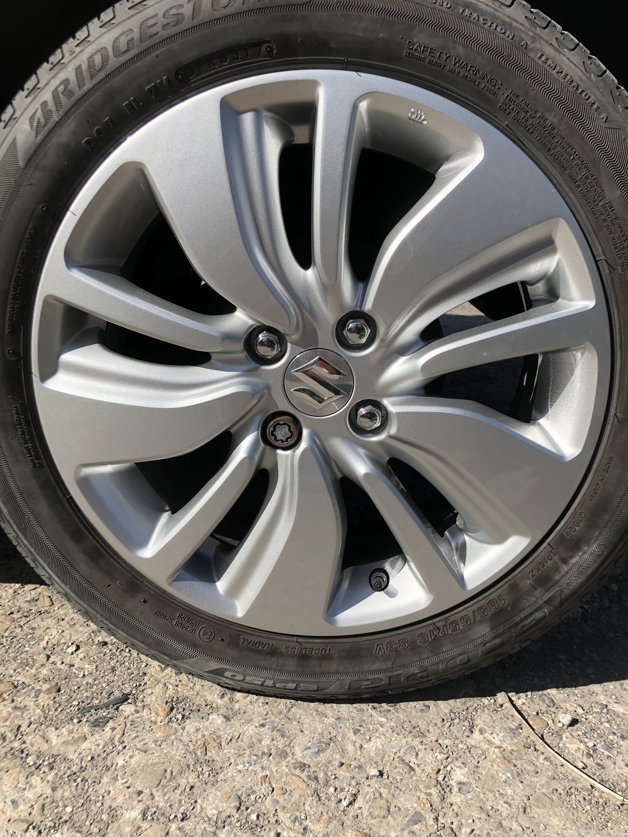 Close detail of a silver Suzuki alloy wheel
